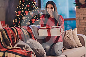 Photo of young attractive beautiful smiling good mood woman sit sofa hold gift present celebrate new year christmas at