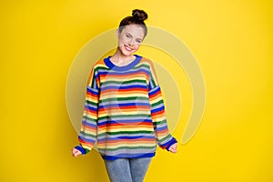 Photo of young attractive cheerful girl positive smile wear rainbow striped pullover isolated over yellow color