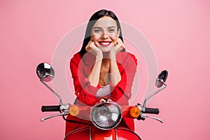 Photo of young attractive girl happy positive smile enjoy dream hands touch cheeks sit bike isolated over pink color