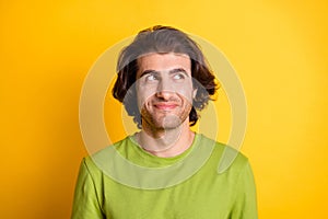 Photo of young attractive man happy positive smile dreamy look empty space isolated over yellow color background