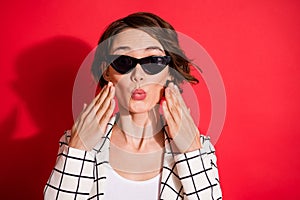 Photo of young attractive woman amazed surprised news rumor wear sunglasses isolated over red color background