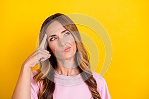 Photo of young attractive woman finger touch head think idea memory isolated over yellow color background photo