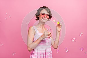 Photo of young attractive woman  have fun air fly soap bubbles wear sarafan isolated over pink color background