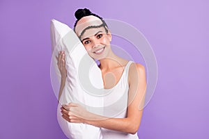 Photo of young beautiful positive smiling girl hug embrace pillow wear pajamas eye mask isolated on purple color