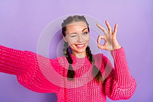 Photo of young beautiful smiling cheerful positive girl take selfie wink eye showing ok sign isolated on purple color