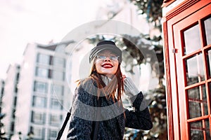 Photo of a young beautiful woman in fashionable cap on the city street.Close up portrait of charming lady. happy girl