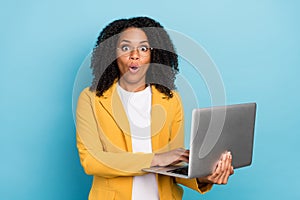 Photo of young black business woman amazed shocked news information use computer isolated over blue color background