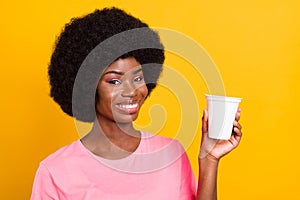 Photo of young black girl happy positive smile show advise suggest pomo food product isolated over yellow color photo