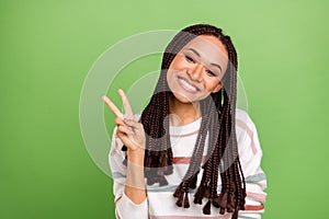 Photo of young black girl happy positive smile show peace cool v-sign isolated over green color background