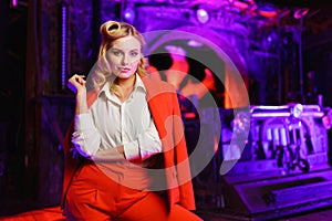Photo of young blonde woman in red suit in nightclub