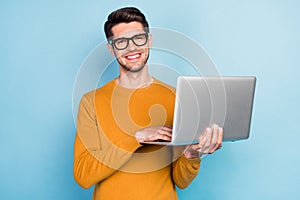 Photo of young business man happy positive smile use laptop work programmer isolated over blue color background