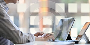 Photo of young businessman typing on computer tablet with keyboard case.