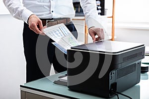 Businessman Using Printer In Office