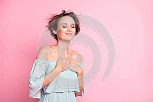 Photo of young charming girl happy positive smile enjoy hands on chest love feelings grateful isolated over pink color