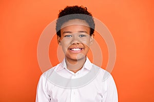 Photo of young cheerful african school boy happy positive smile learning study isolated over orange color background