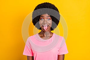 Photo of young cheerful afro girl happy positive smile fooling tongue-out isolated over yellow color background