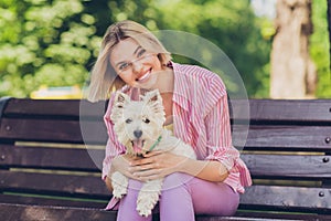 Photo of young cheerful girl happy positive smile embrace doggy puppy friendship sit bench park outdoors