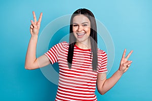 Photo of young cheerful girl happy positive smile show peace cool v-sign isolated over blue color background