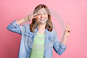 Photo of young cheerful girl happy positive smile show peace cool v-sign  over pink color background