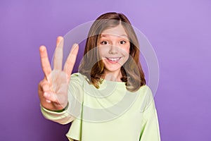 Photo of young cheerful girl happy positive smile show three fingers amount math isolated over violet color background