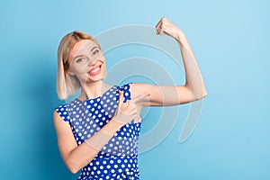 Photo of young cheerful girl happy smile point finger arms muscle biceps sportive isolated over blue color background