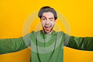 Photo of young cheerful happy positive man wink eye make selfie camera isolated on yellow color background