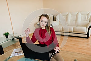 Photo of young cheerful happy woman indoors at home using laptop computer talking by mobile phone