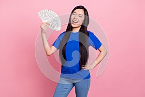 Photo of young cheerful joyful asian woman hold hands money banknote enjoy isolated on pink color background