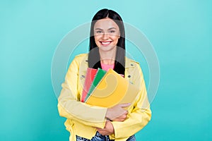 Photo of young cheerful lady hug notebook homework study youngster isolated over turquoise color background