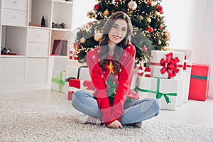 Photo of young cheerful pretty brown long hairstyle girl wear red ugly sweater sitting crossed legs wish more gifts