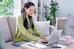 Photo of young cheerful woman sit sofa use laptop remote education indoors inside house home flat