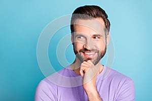 Photo of young cheerful young man happy positive smile hand touch chin think look empty space isolated over blue color