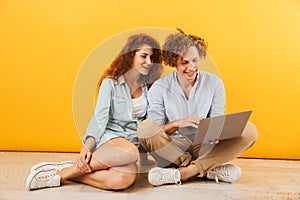 Photo of young content couple man and woman 20s sitting on floor