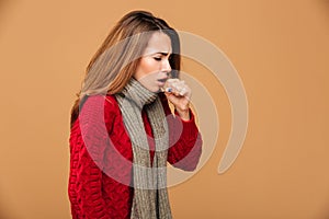 Photo of young coughing brunette woman in warm wear
