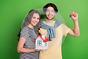 Photo of young couple happy positive smile buy real estate house key relocation isolated over green color background