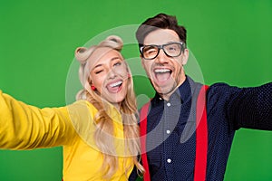 Photo of young couple have fun grimace fooling discotheque make selfie 50s isolated over green color background