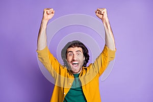 Photo of young crazy happy triumphant ecstatic male man guy raise fists shout isolated on purple color background