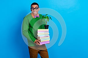 Photo of young cute smiling academic nerd student man wear funky spectacles hold stack books with decorative plant