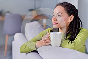 Photo of young dreamy afro american peaceful woman look hold hand mug indoors inside house home flat