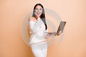 Photo of young excited girl happy positive smile amazed surprised use laptop isolated over beige color background