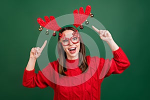 Photo of young excited girl happy positive smile indicate fingers headband horns costume isolated over green color