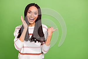 Photo of young excited girl happy positive smile indicate thumb empty space suggest sale isolated over green color