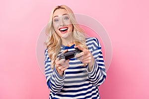 Photo of young excited hobby girl playing gamepad wear stylish shirt crazy gamer enjoy mortal kombat isolated on pink