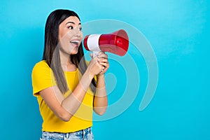 Photo of young excited japanese girl hold megaphone scream loudspeaker empty space announcement isolated on blue color