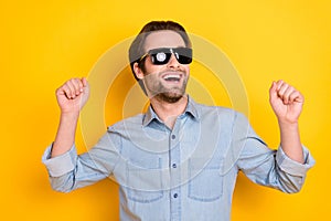 Photo of young excited man happy positive smile have fun dance party isolated over yellow color background