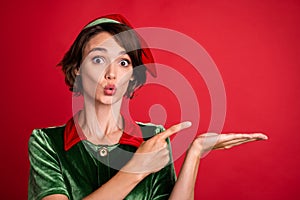Photo of young excited woman pouted lips amazed point finger product promo advertise isolated over red color background