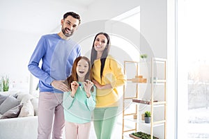 Photo of young family happy positive smile kid hold key buy purchase new house moving relocation indoors