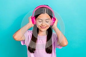 Photo of young funky girl brunette hair wear pink t-shirt listen music stereo sound high quality itunes isolated on blue photo