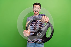 Photo of young funny overjoyed driver automobile guy holding steering wheel crazy surprised high speed isolated on green