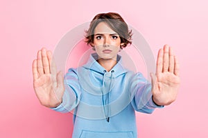 Photo of young funny serious attractive perfect woman wear blue hoodie showing no hands because taboo isolated on pink